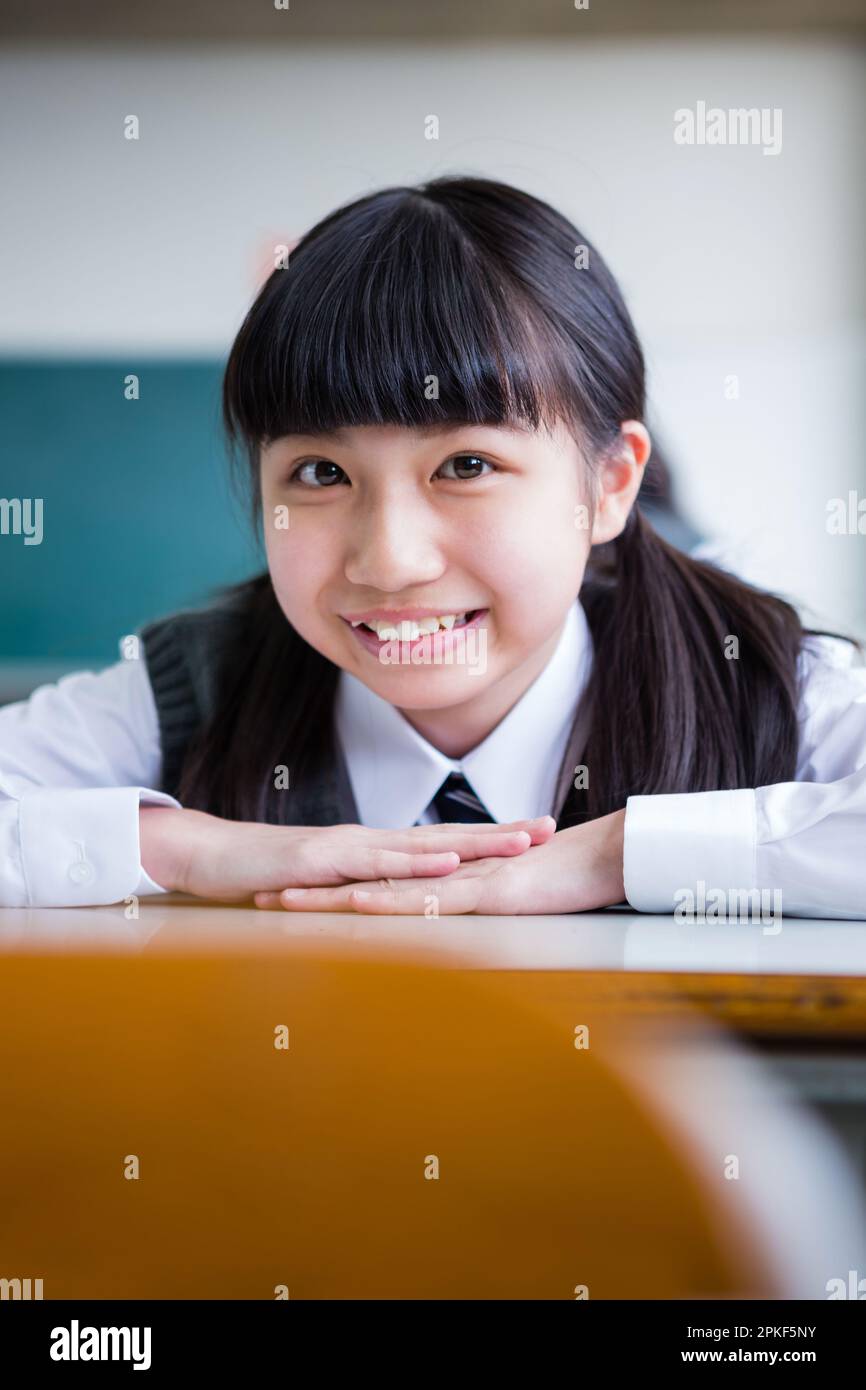 Junior high school girls leaning on a desk Stock Photo