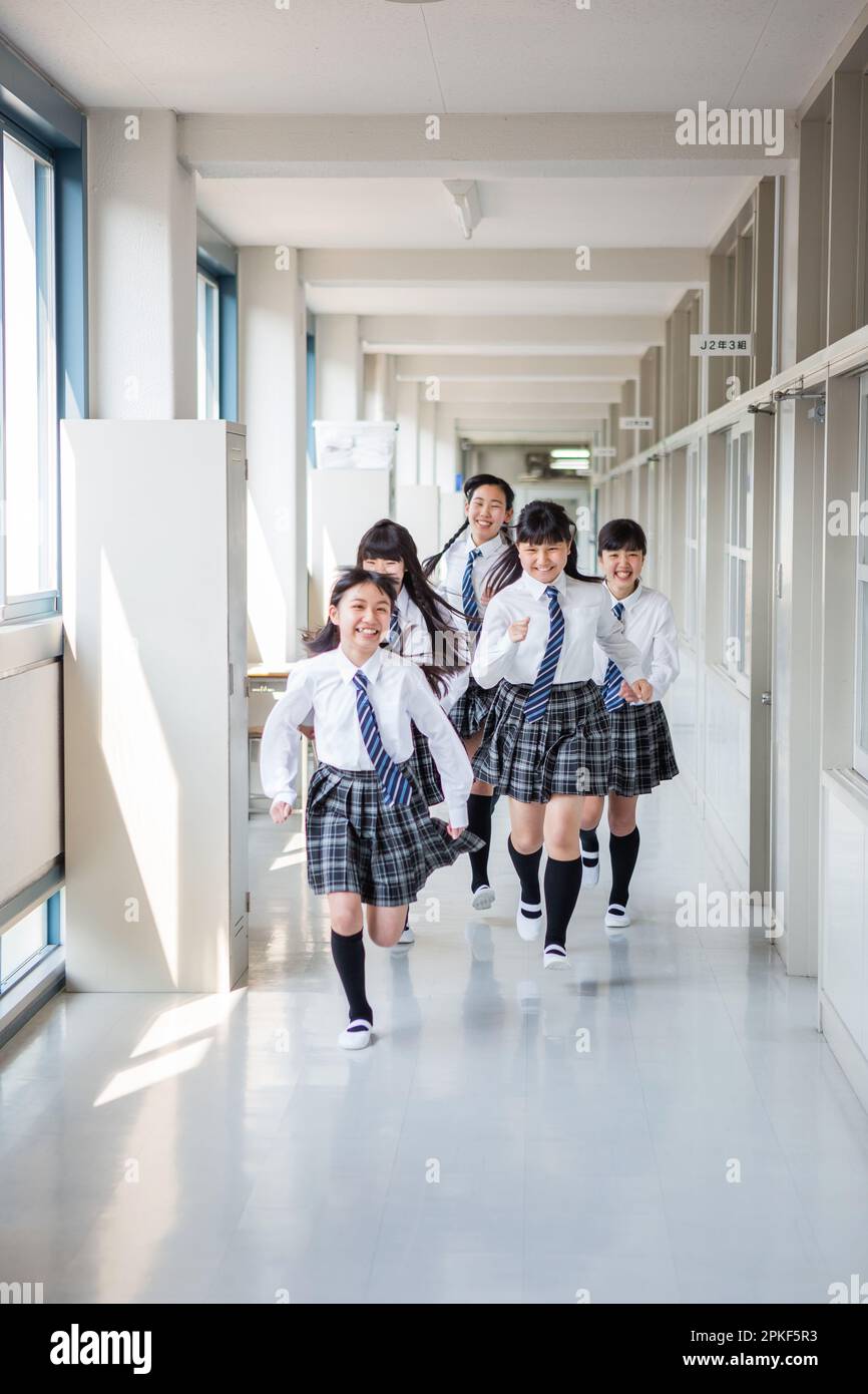 Junior high school girls running in the hallway Stock Photo