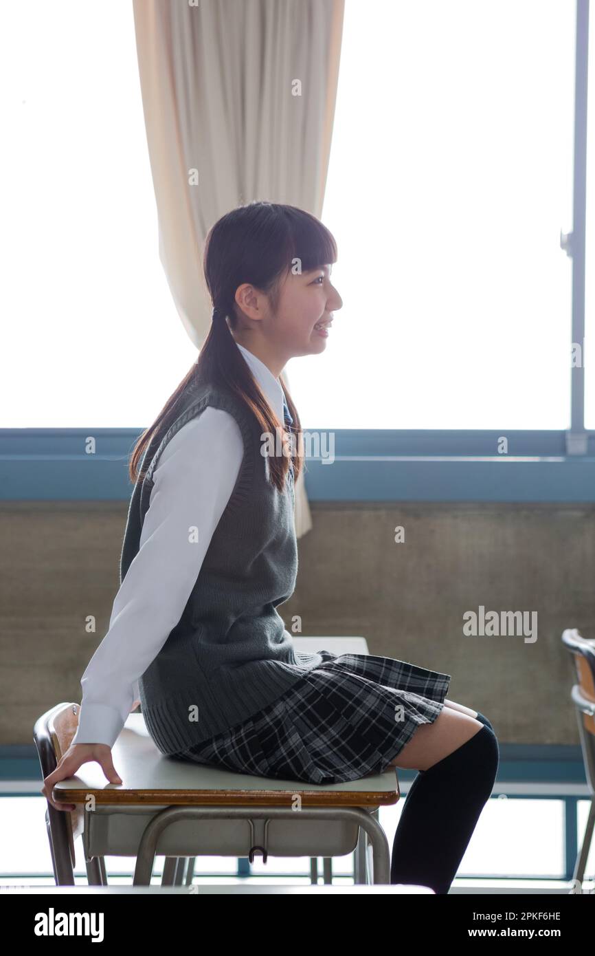 Junior high school girl sitting at a desk in a classroom Stock Photo ...