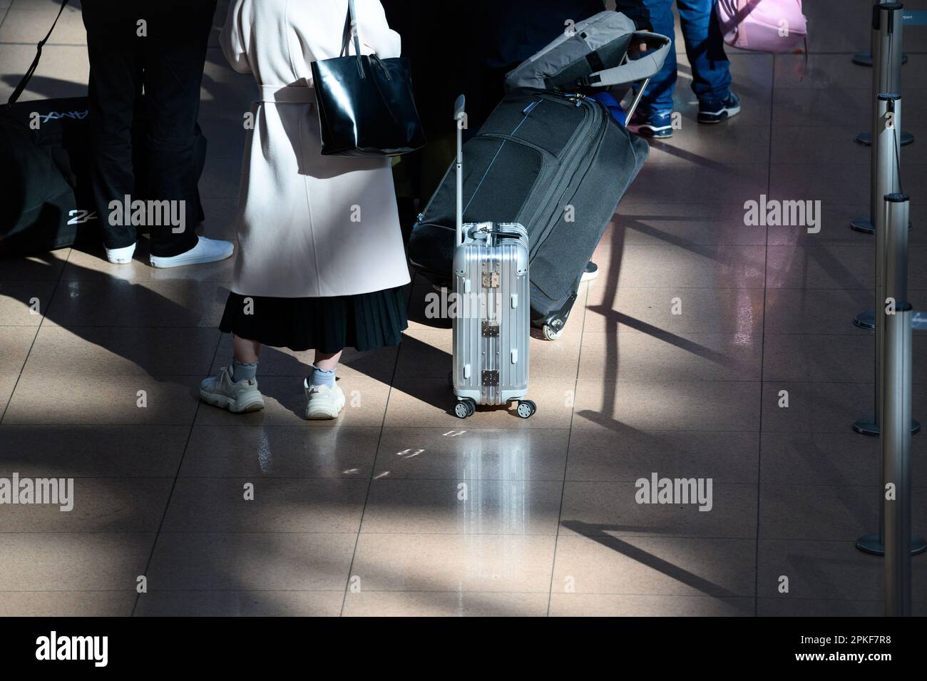 Hamburg, Germany. 07th Apr, 2023. Travelers stand in line with their luggage in the sunshine in Terminal 1 at Hamburg Airport. Credit: Jonas Walzberg/dpa/Alamy Live News Stock Photo