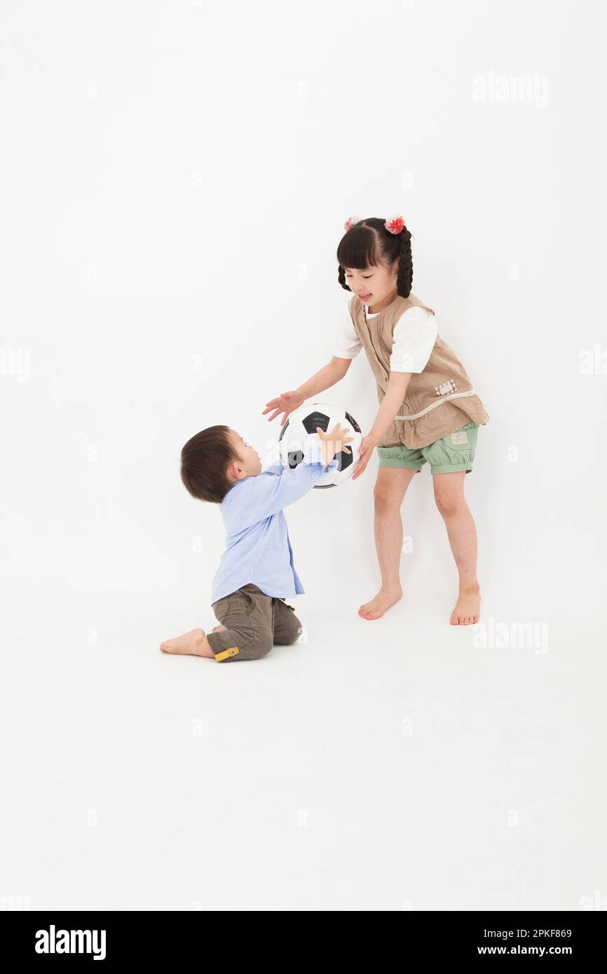 Boy and girl playing with soccer ball Stock Photo