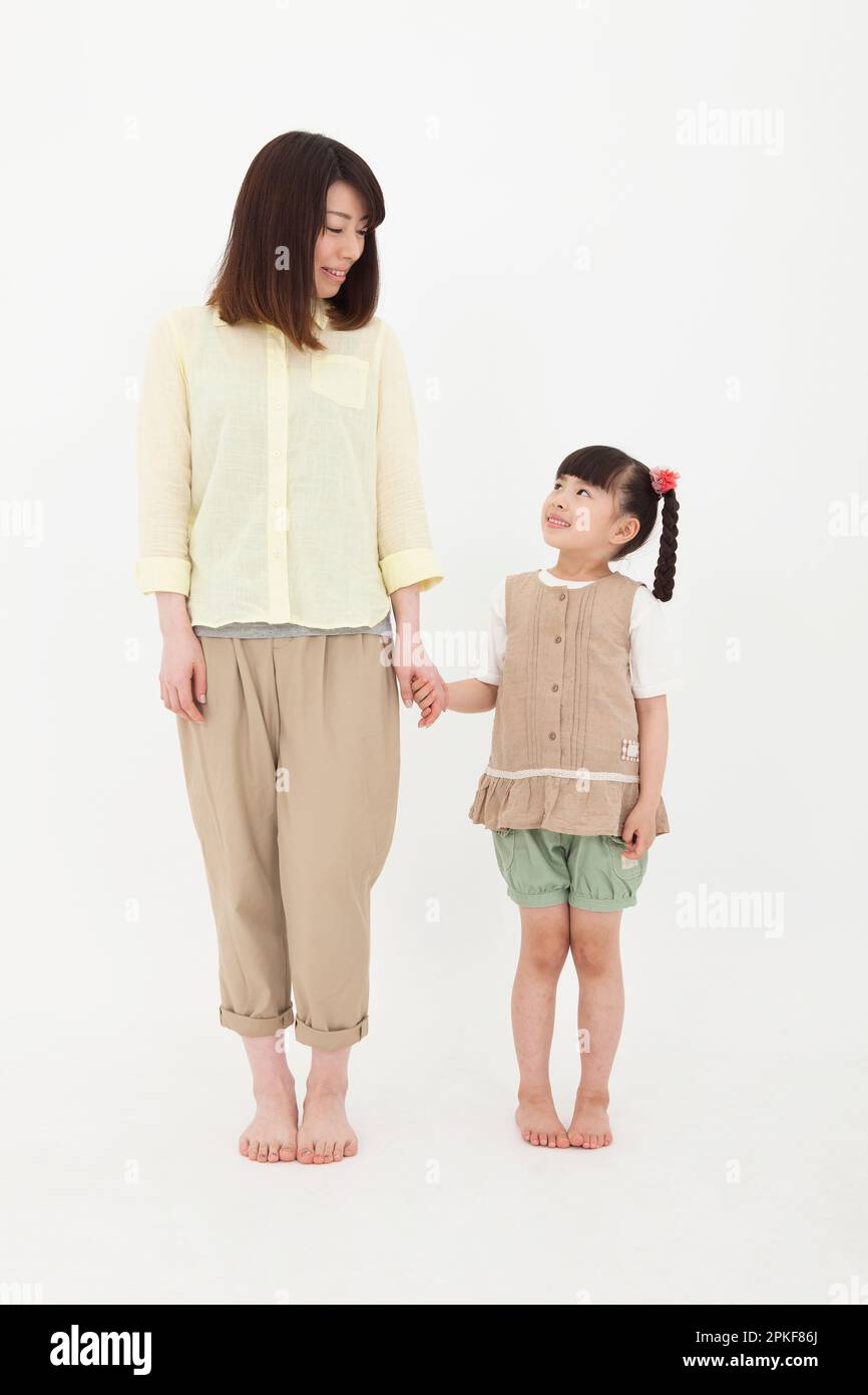 Woman Holding Hands With Girl Stock Photo
