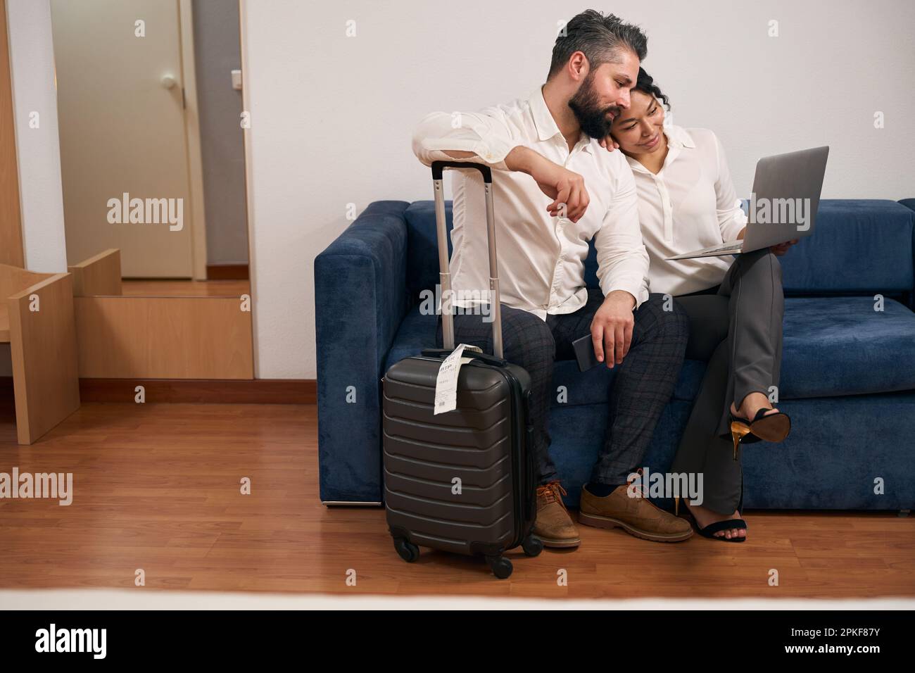 Man and woman using portable computer in hotel room Stock Photo