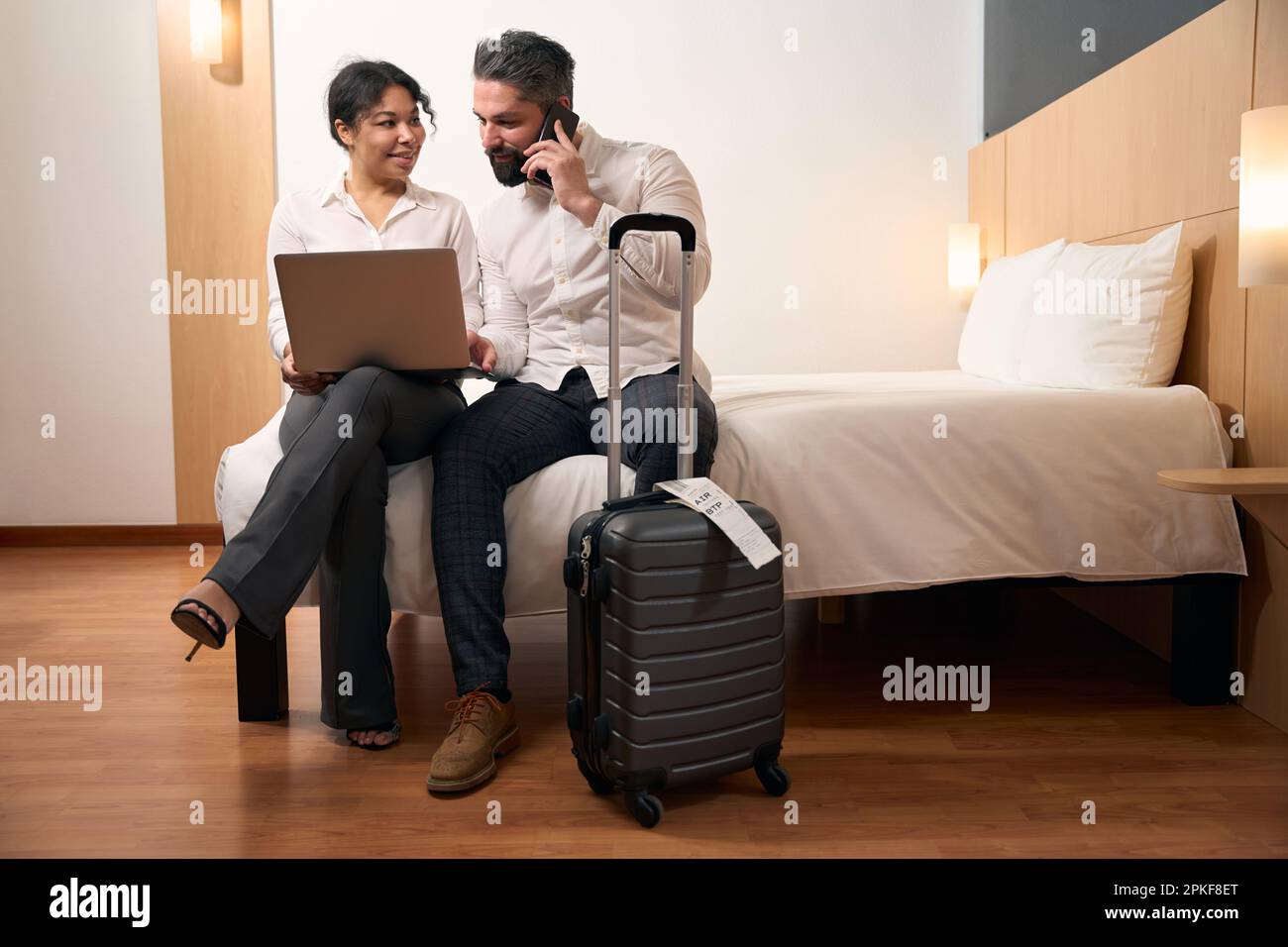 Couple with portable computer sitting in hotel room Stock Photo