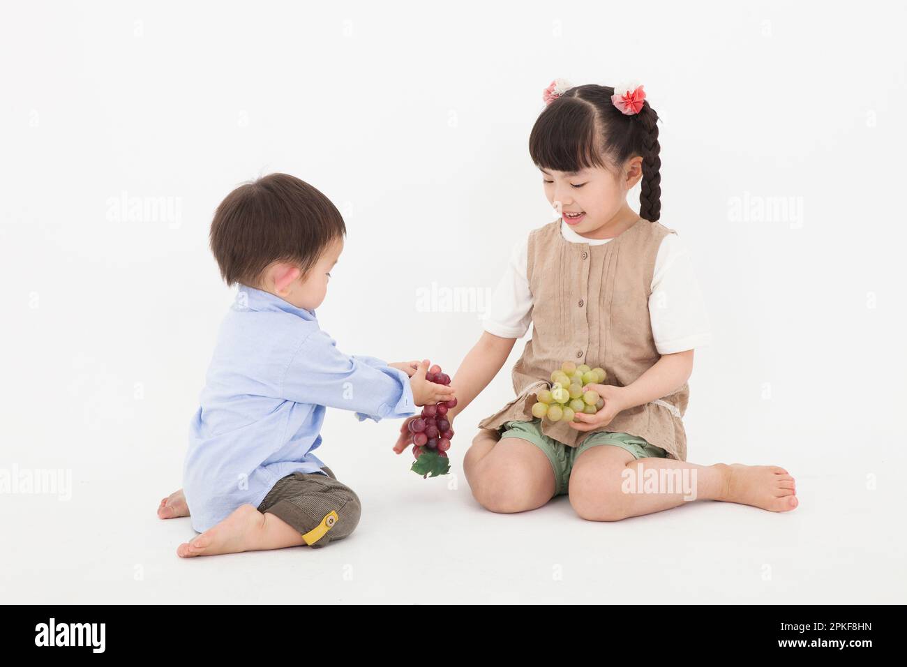 Boy and girl sitting and playing Stock Photo
