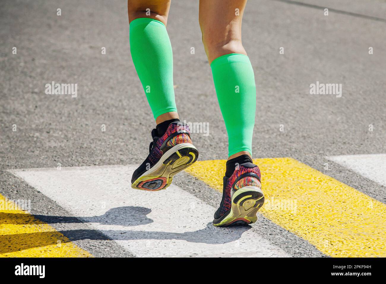 legs female runner in bright green compression socks running pedestrian ...