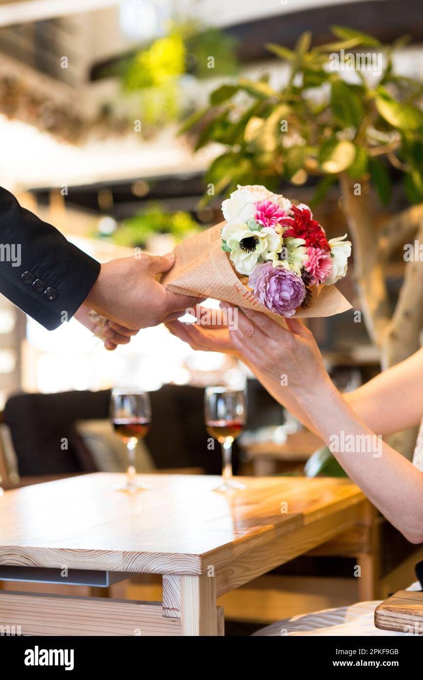 Husband handing bouquet of flowers to wife Stock Photo Alamy