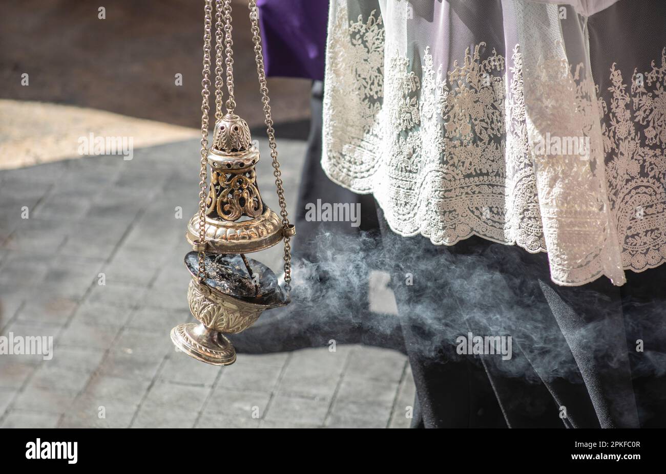 Detail of altar boy dressed in lace with censer in a Holy Week