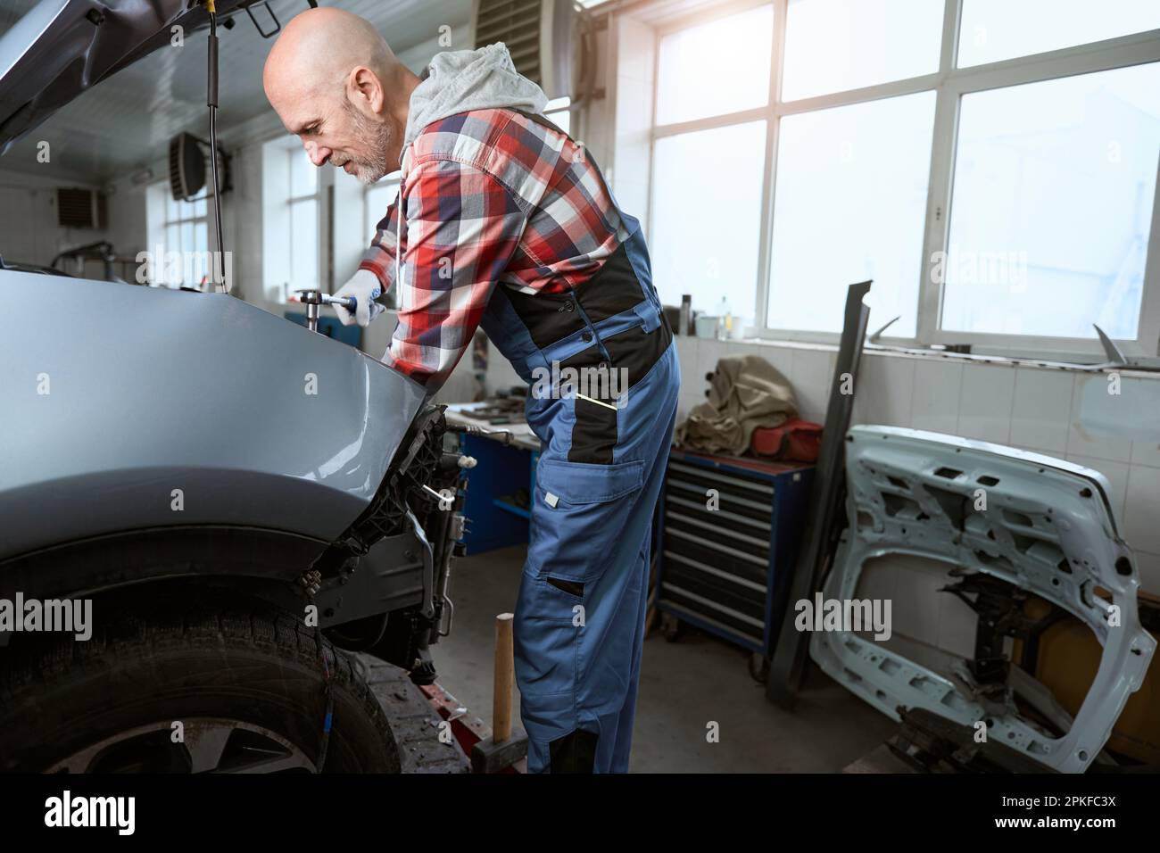 Auto repairman at the workplace repairs a car Stock Photo