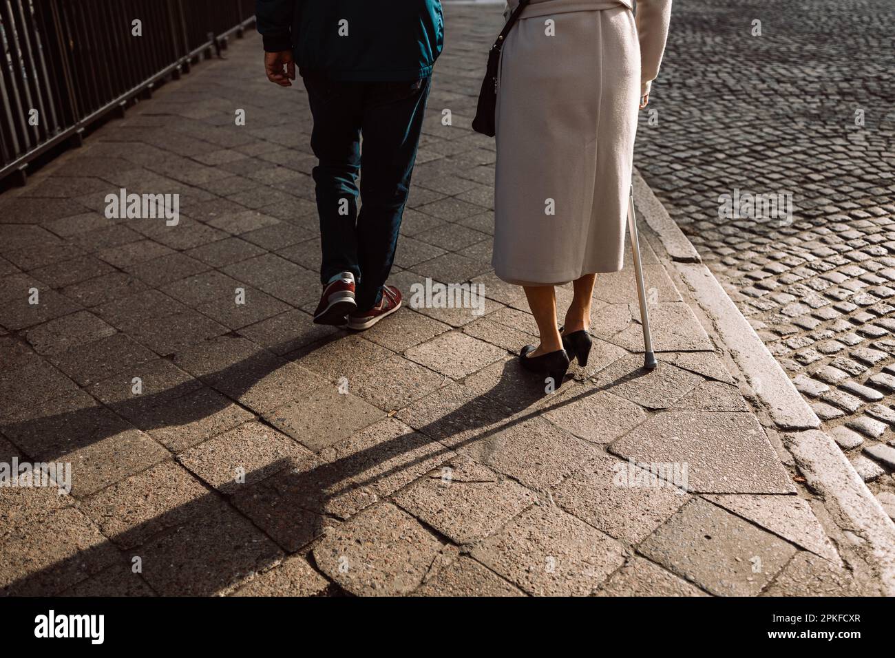 Man Limping Old couple feet walk at old city. Limping woman with cane and man ...