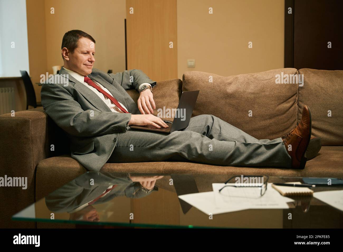 Man in a business suit works on a laptop Stock Photo