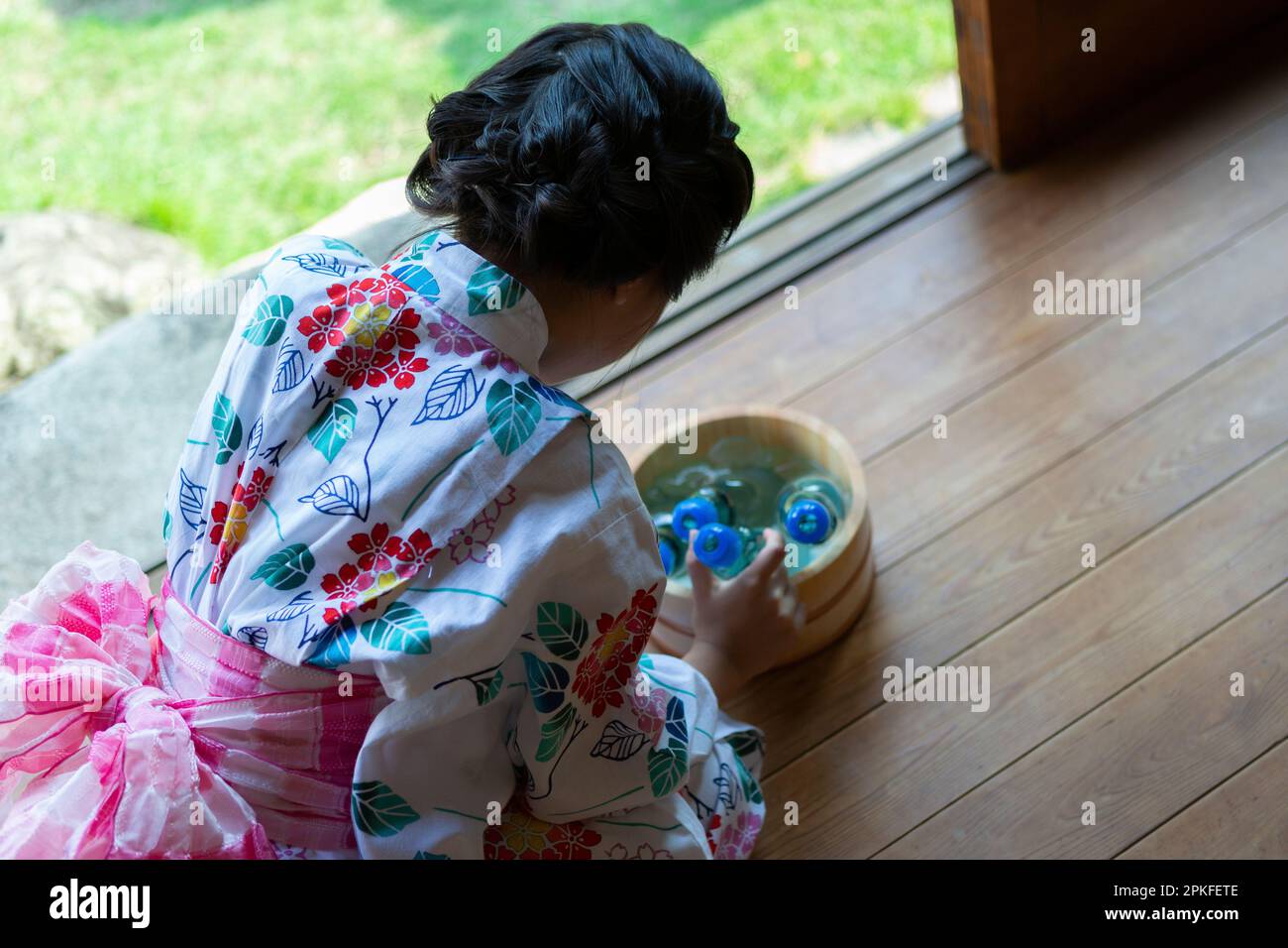 Girl dipping a Ramune in ice Stock Photo