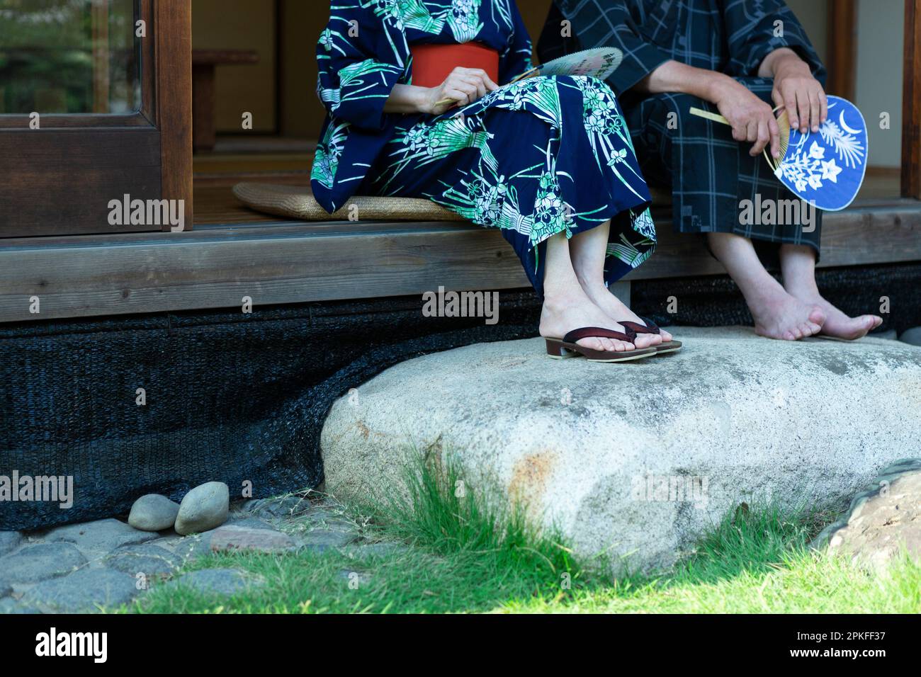 Old couple sitting on the porch at their feet Stock Photo