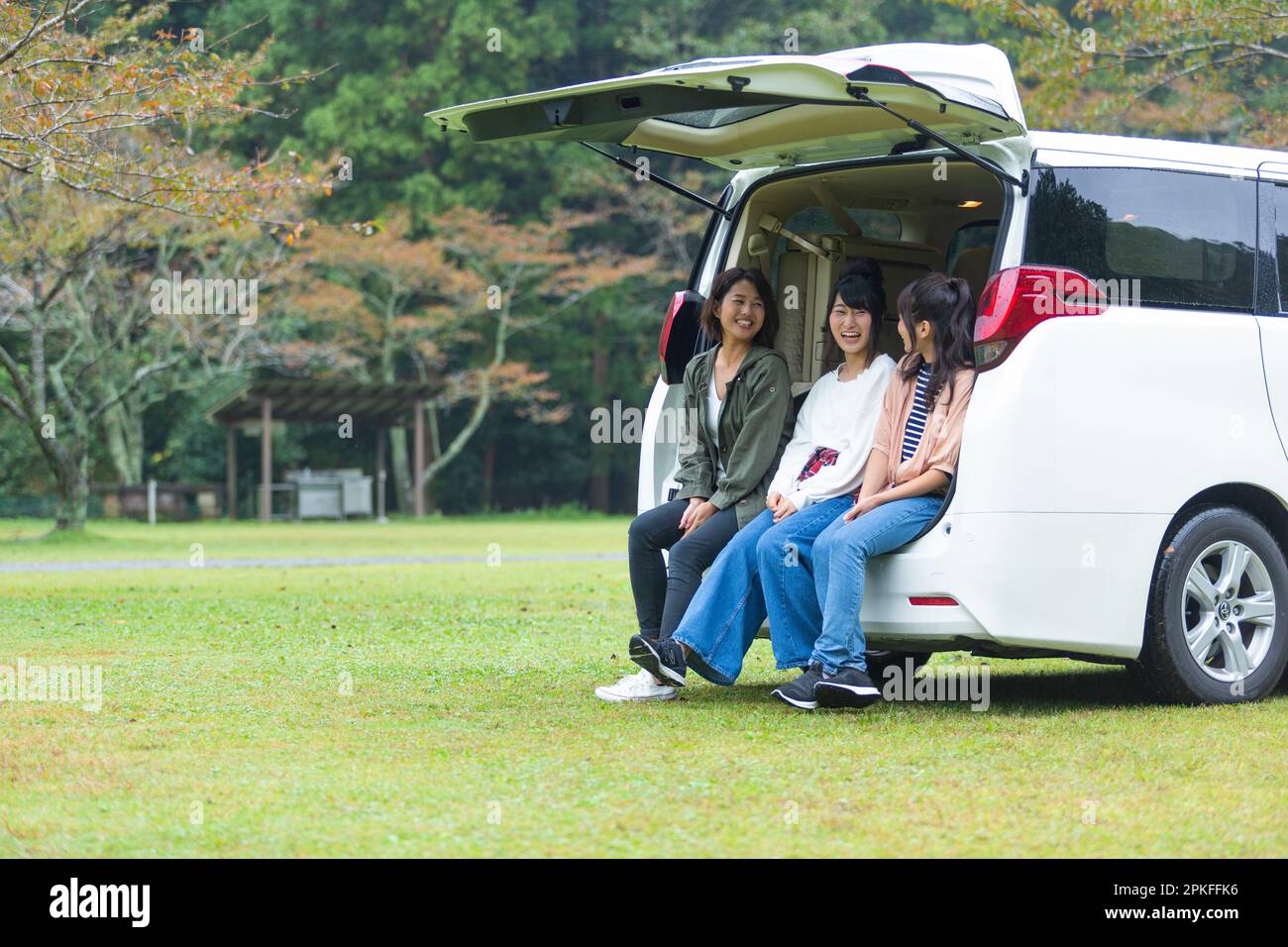 Woman sitting and chatting in the trunk of a car Stock Photo