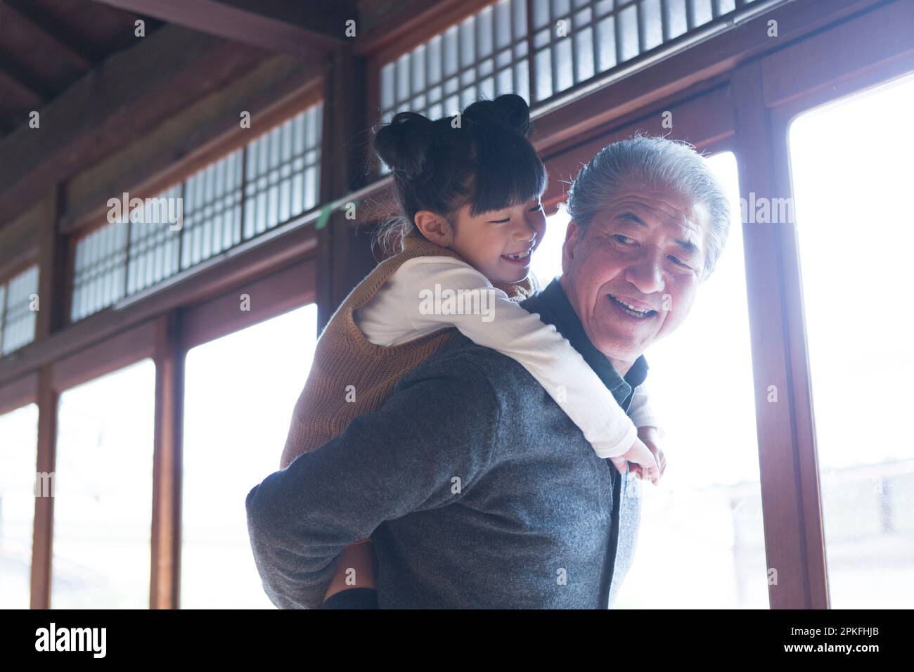 Senior man and grandson giving a piggyback ride in a country house Stock Photo
