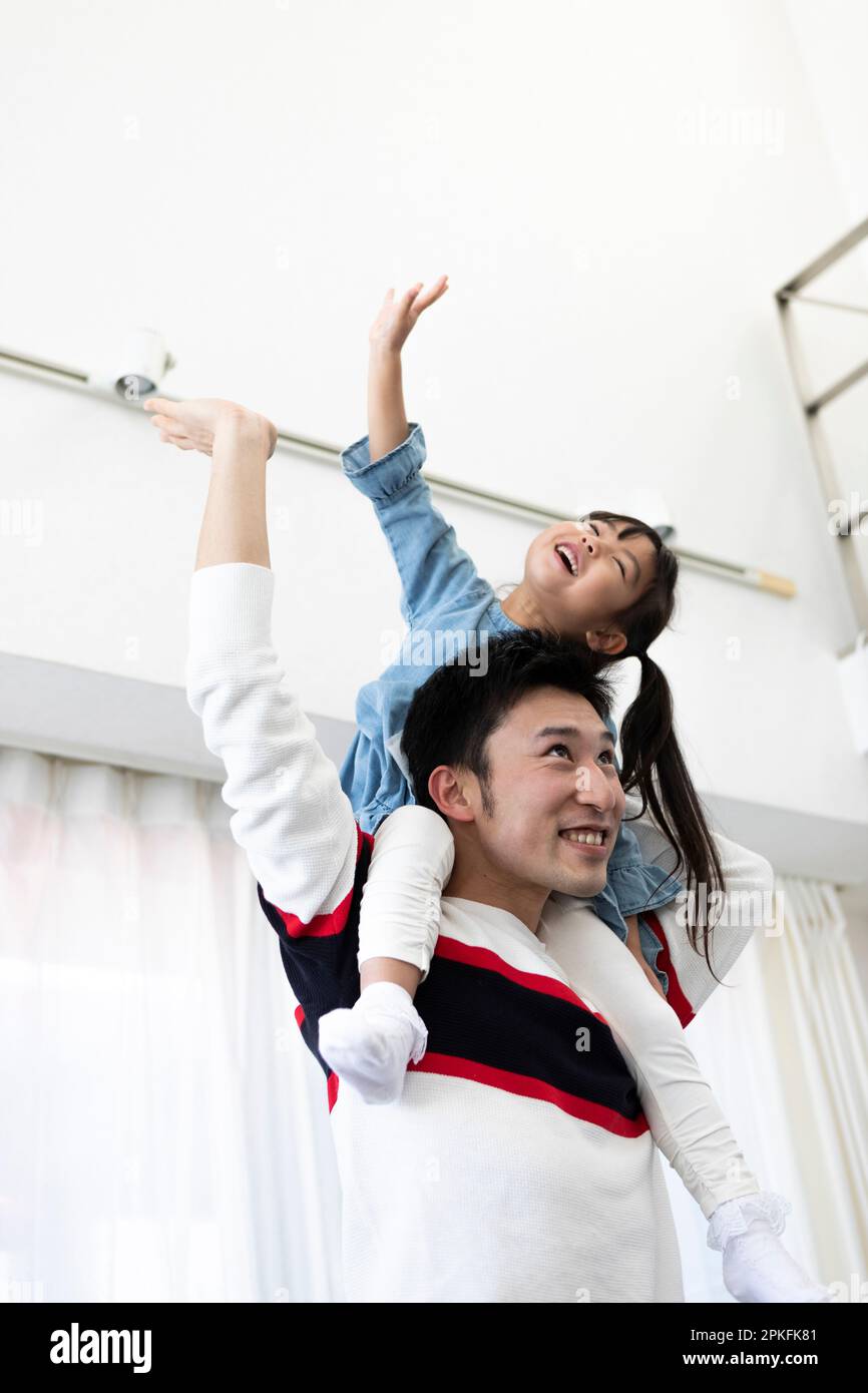 Father and daughter riding on each other's shoulders Stock Photo