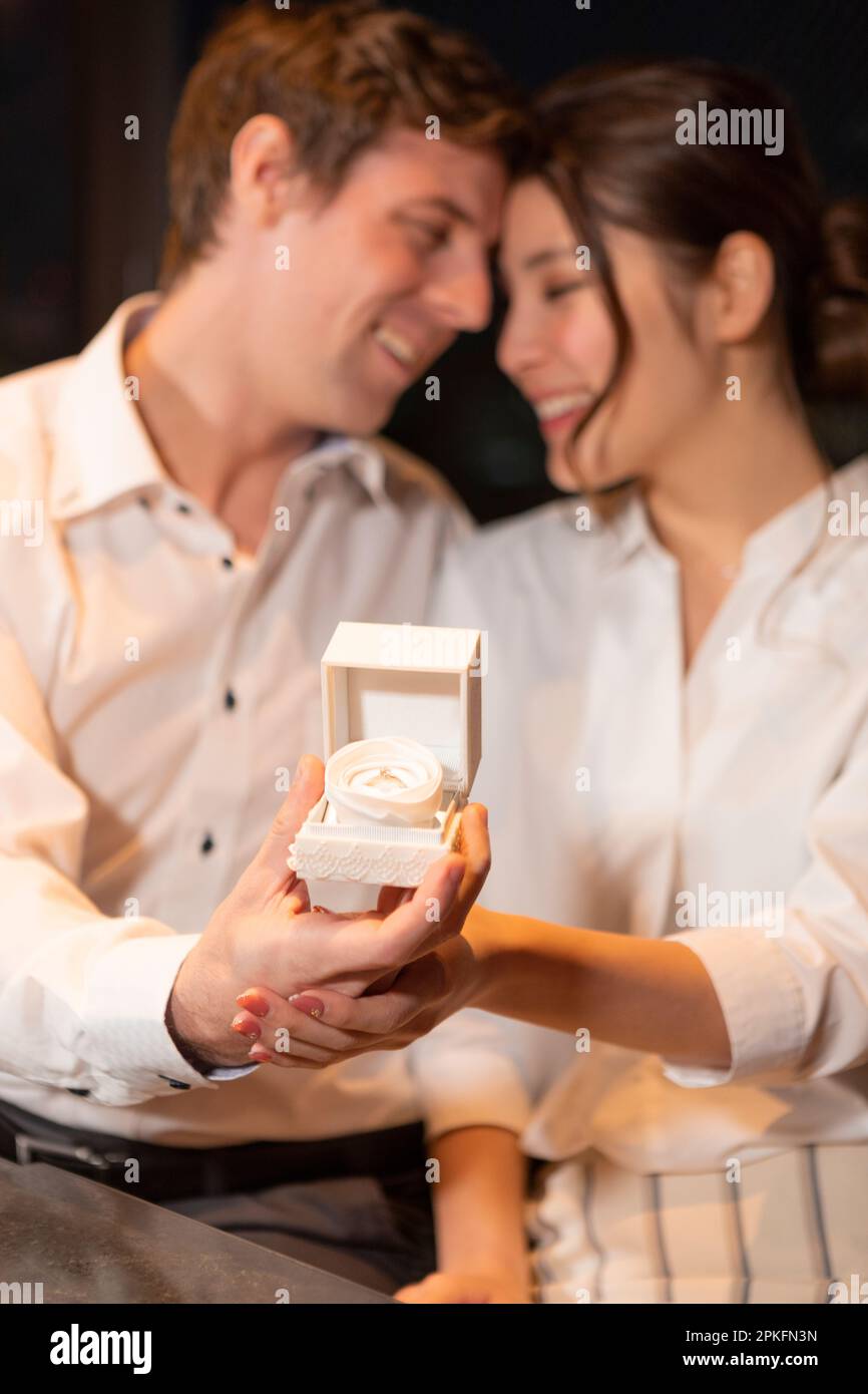 Couple holding engagement rings and looking at each other Stock Photo