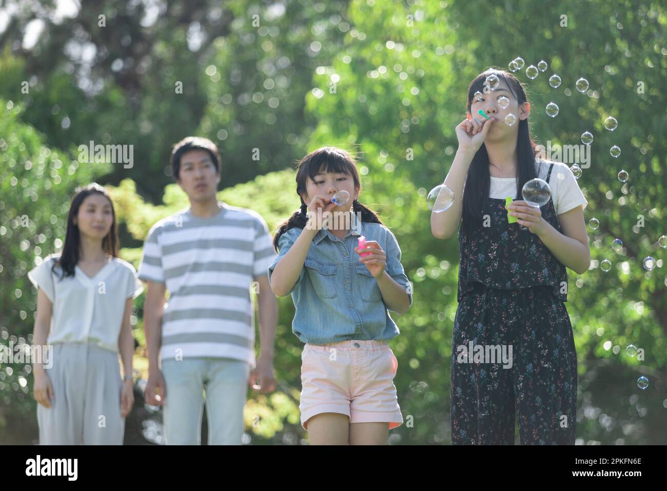 Family playing with soap bubbles Stock Photo