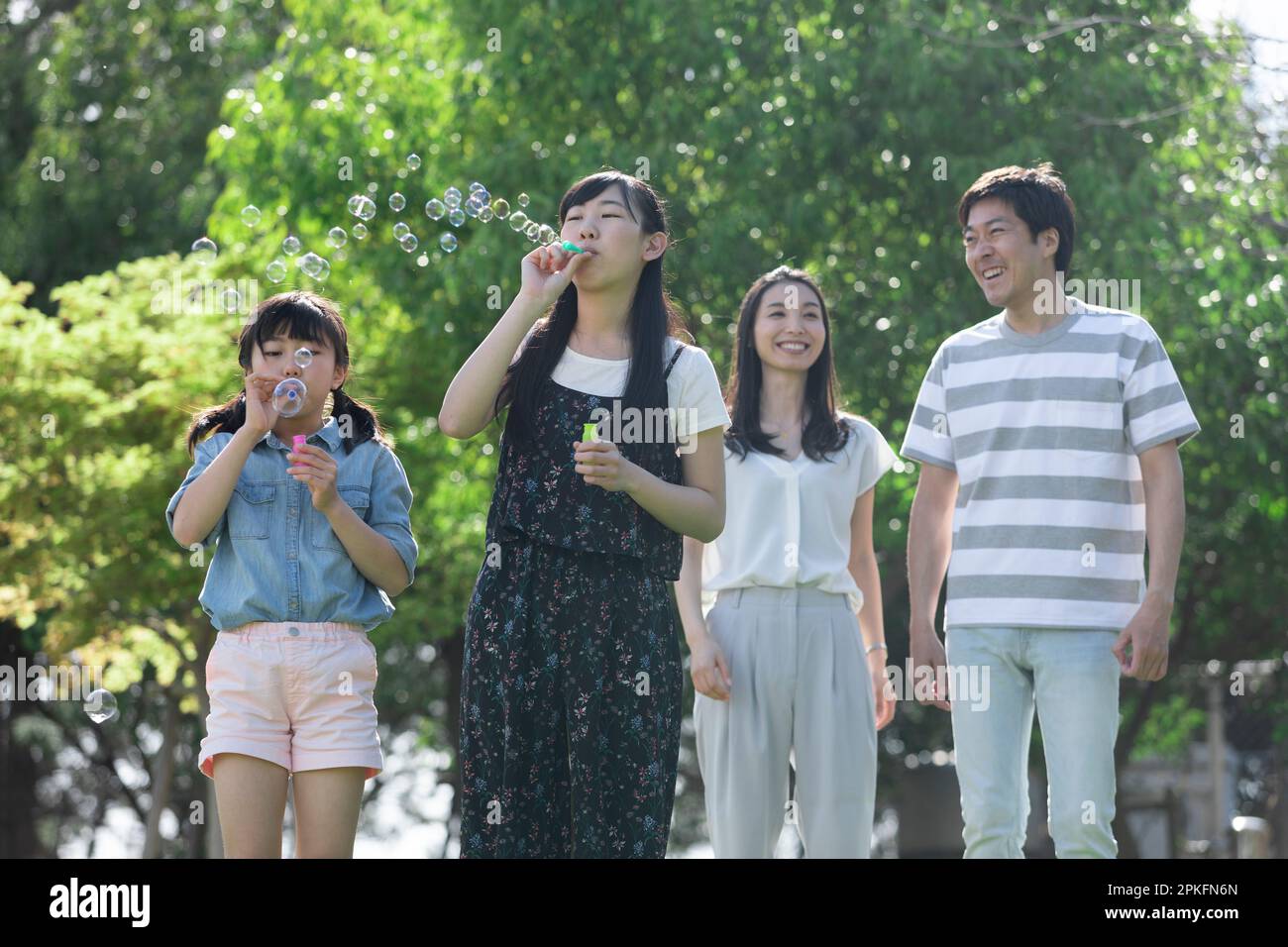 Family playing with soap bubbles Stock Photo