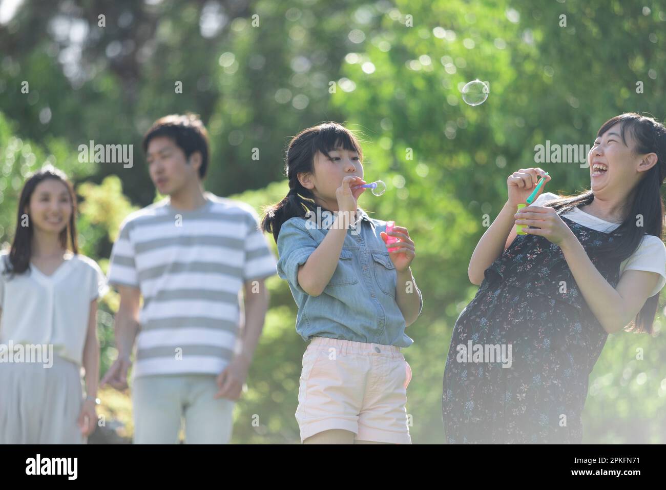 Family playing with soap bubbles Stock Photo