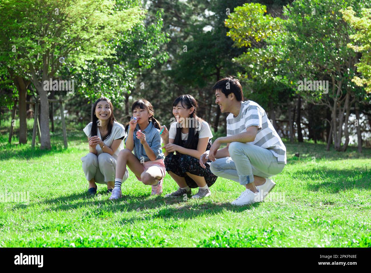 Family playing with soap bubbles Stock Photo