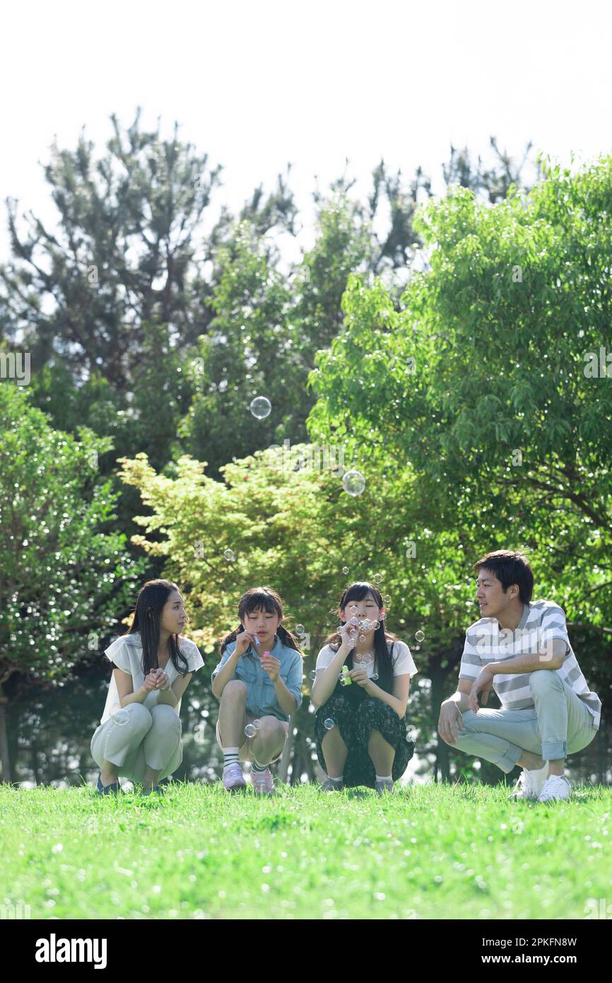 Family playing with soap bubbles Stock Photo