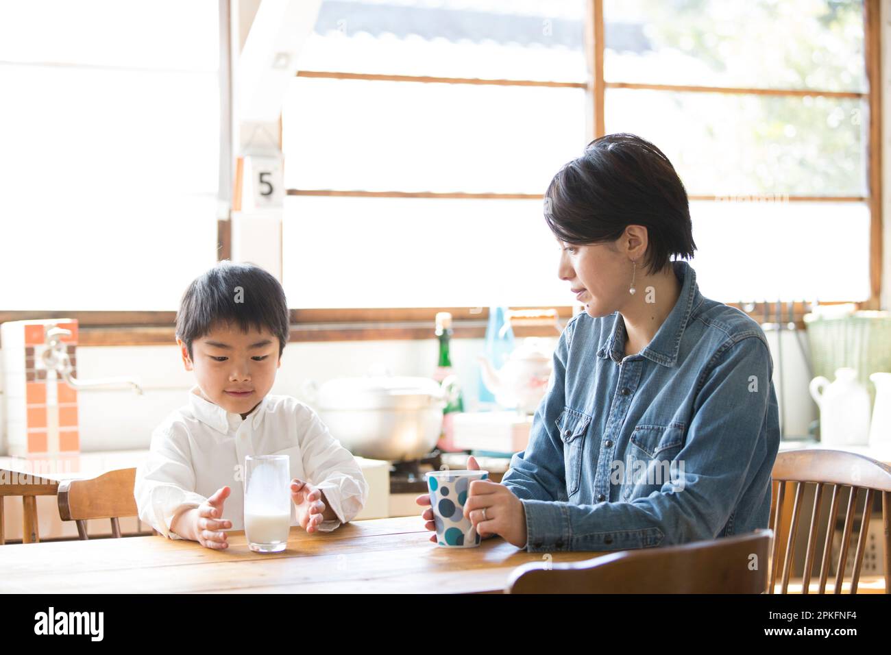 Boy drinking milk with his mother Stock Photo