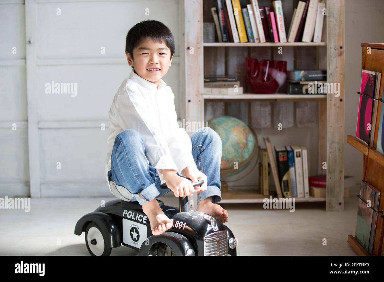 Boy playing on a toy car Stock Photo - Alamy