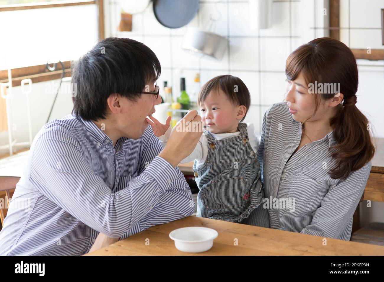 Family relaxing at the kitchen table Stock Photo