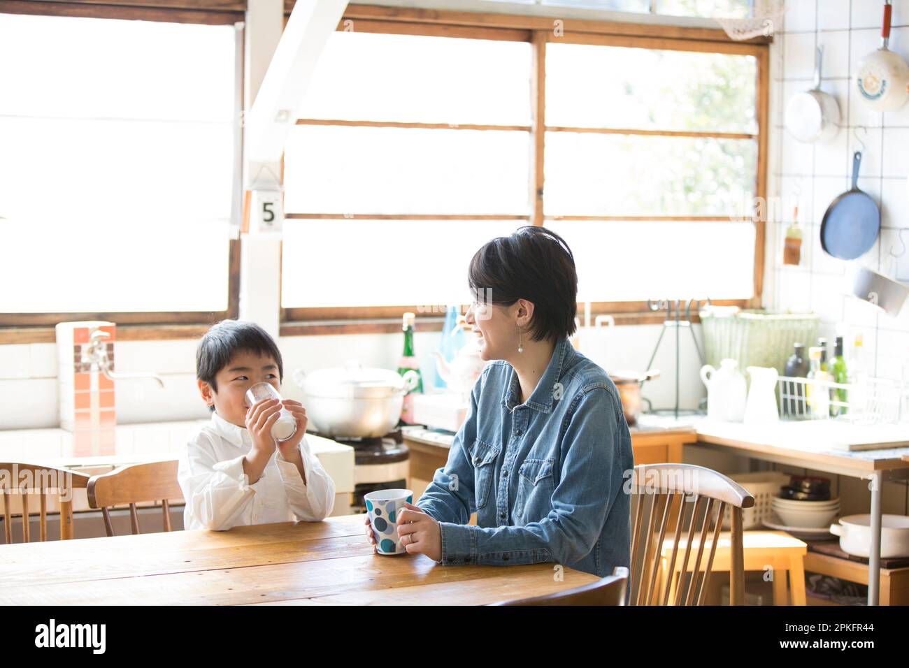 Boy drinking milk with his mother Stock Photo