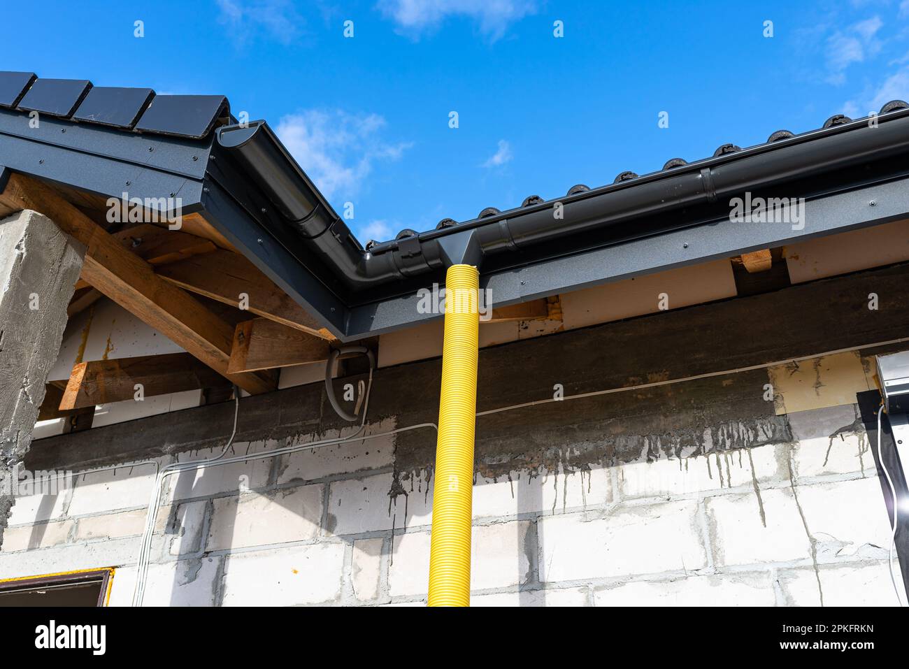 100mm diameter yellow PVC pipe connected to the end of the gutter on