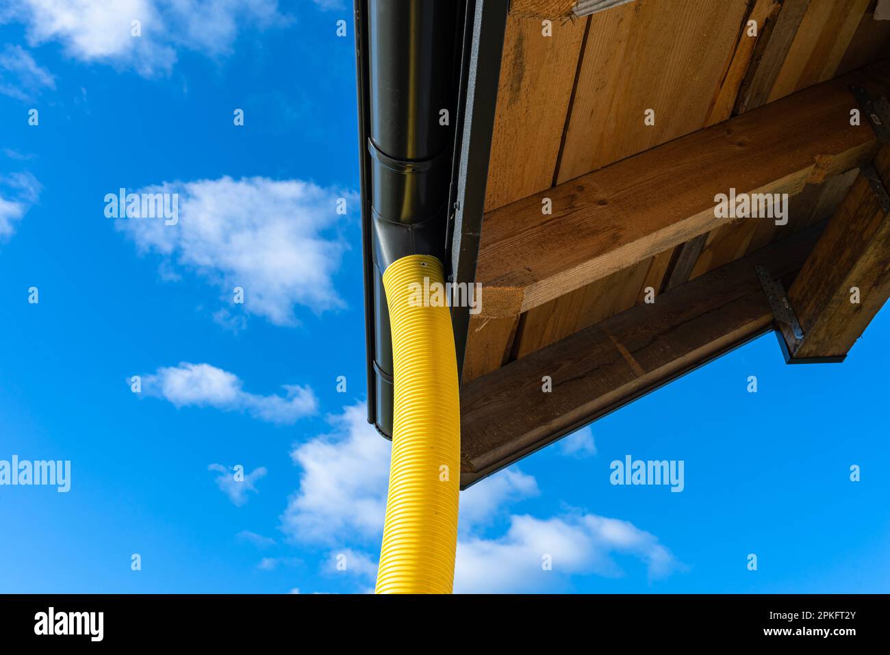 100mm diameter yellow PVC pipe connected to the end of the gutter on