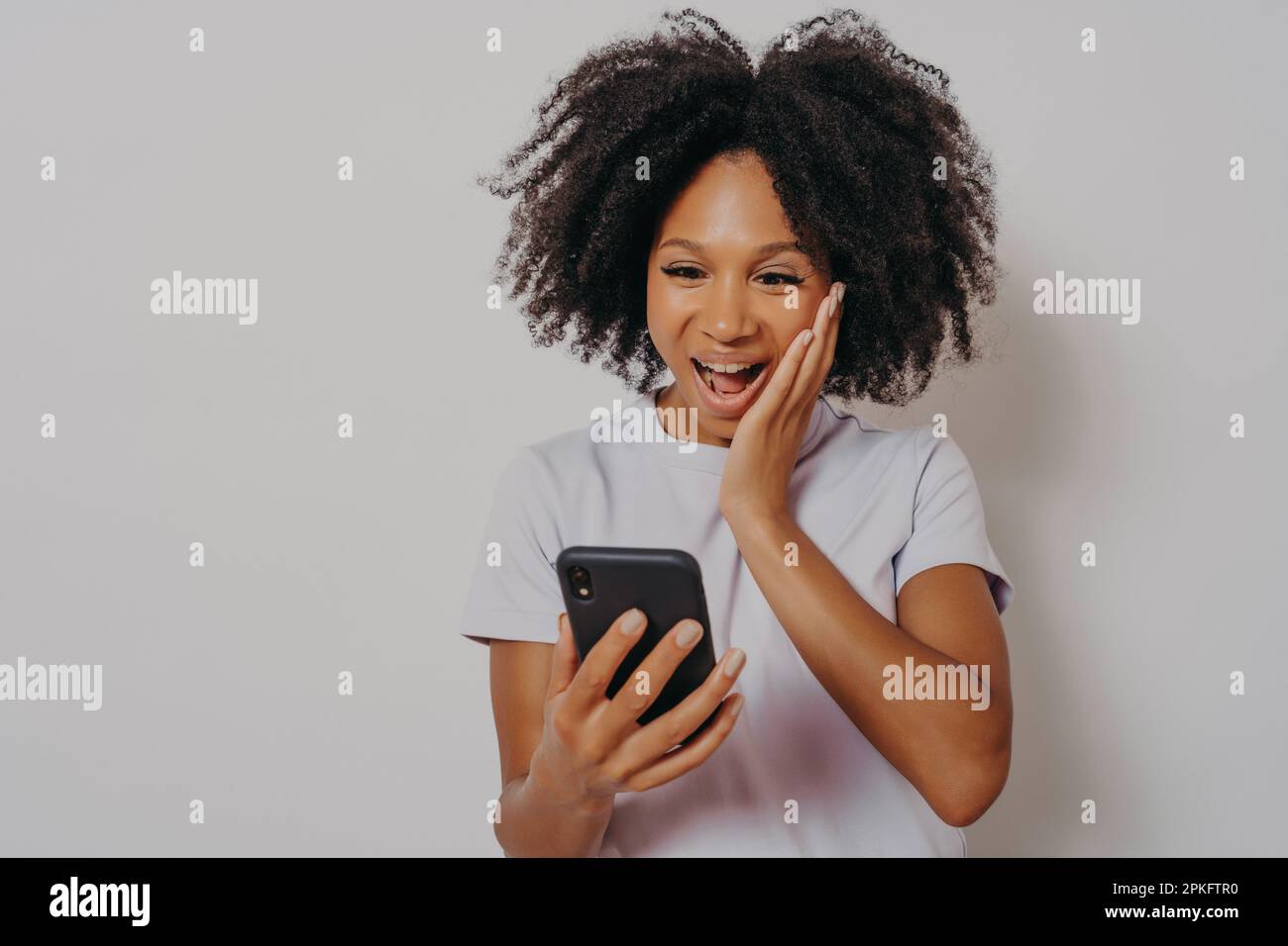 Excited mixed race ethnicity millennial girl isolated on white studio