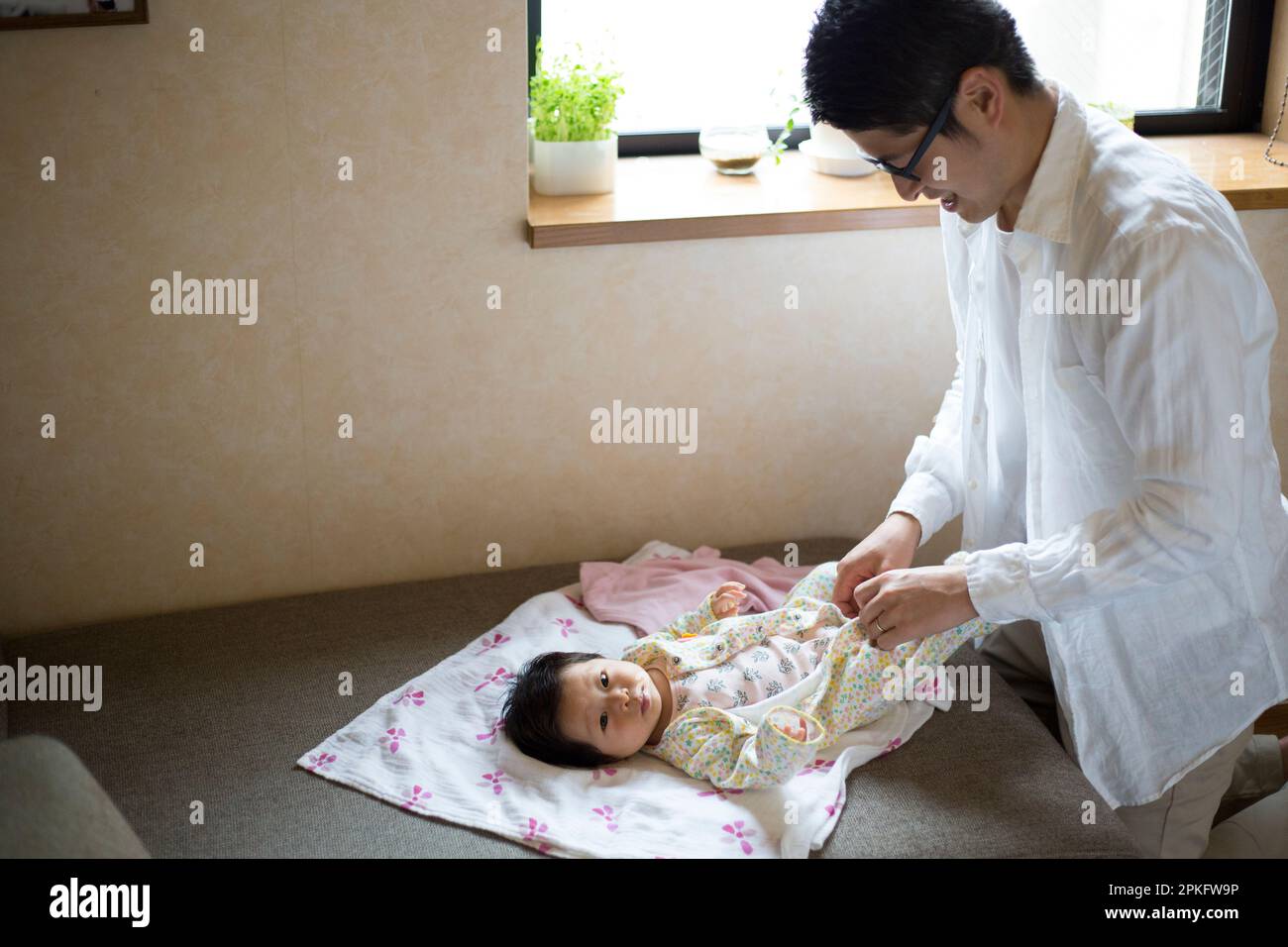 Father changing baby's clothes Stock Photo Alamy
