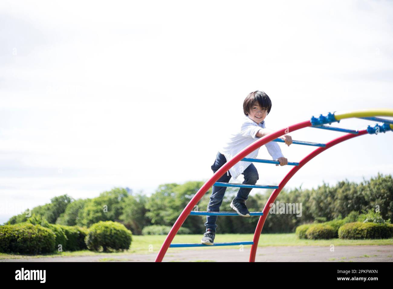 Elementary school boy playing on the playground equipment Stock Photo