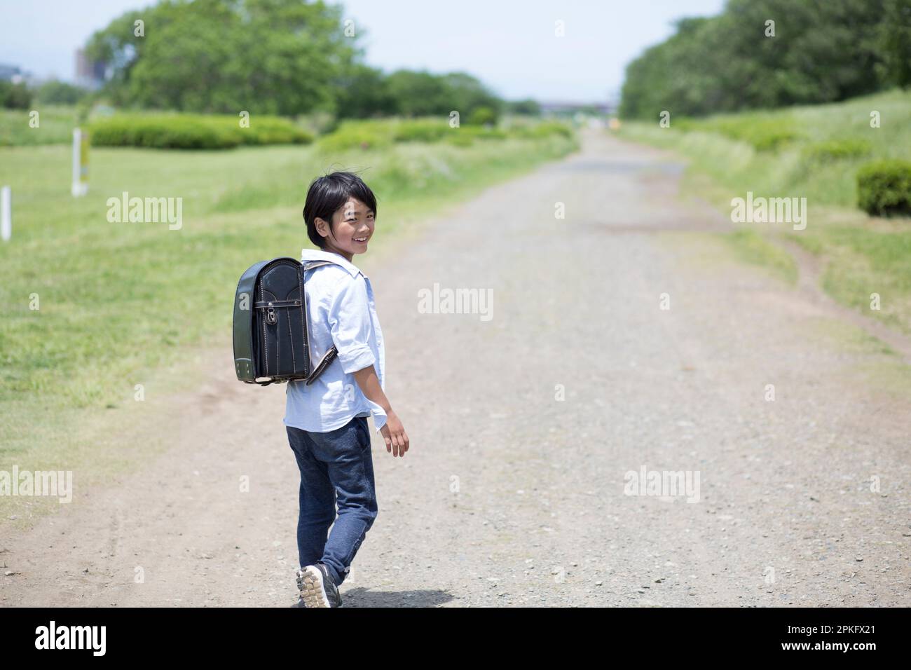 Boy walking with school bag on his back Stock Photo - Alamy