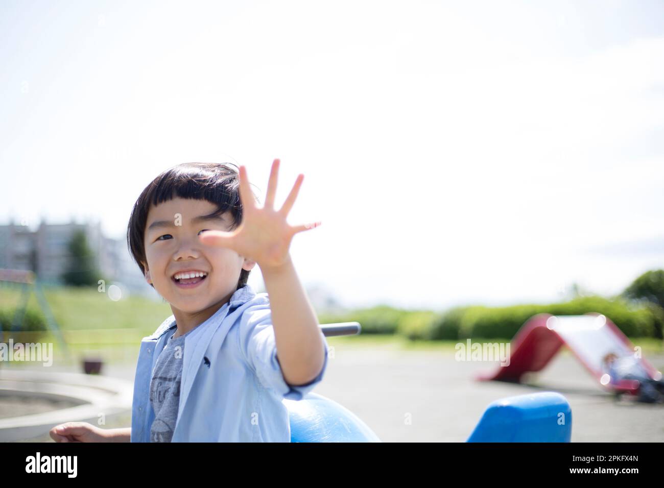 A boy playing rockpaperscissors on the playground equipment at the