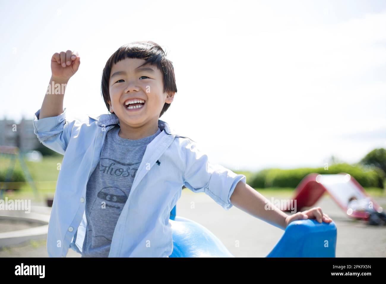 Boy playing rockpaperscissors on the playground equipment at the park