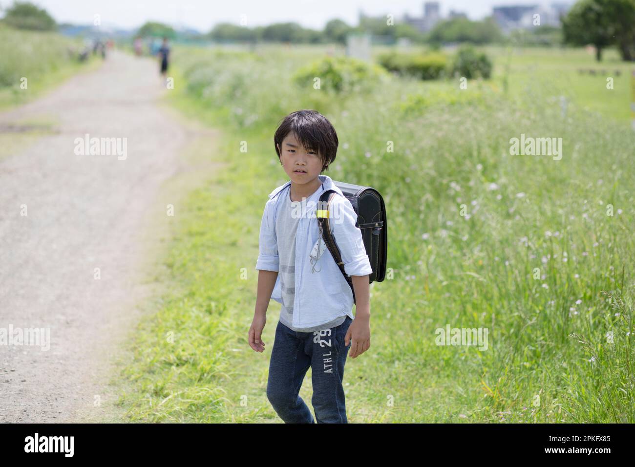 Boy walking with school bag on his back Stock Photo - Alamy