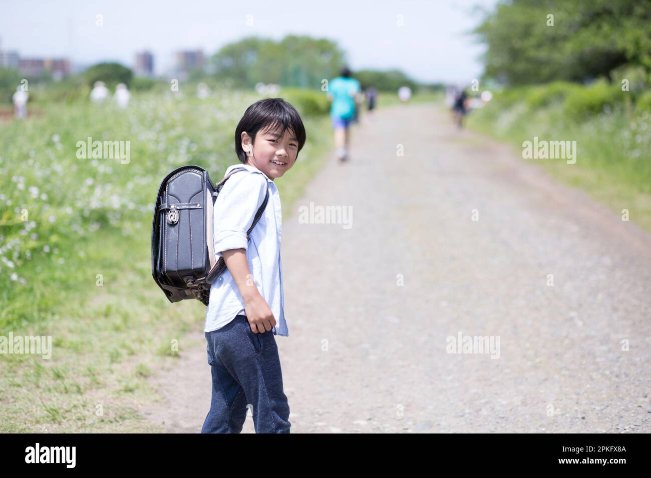 Boy walking with school bag on his back Stock Photo - Alamy