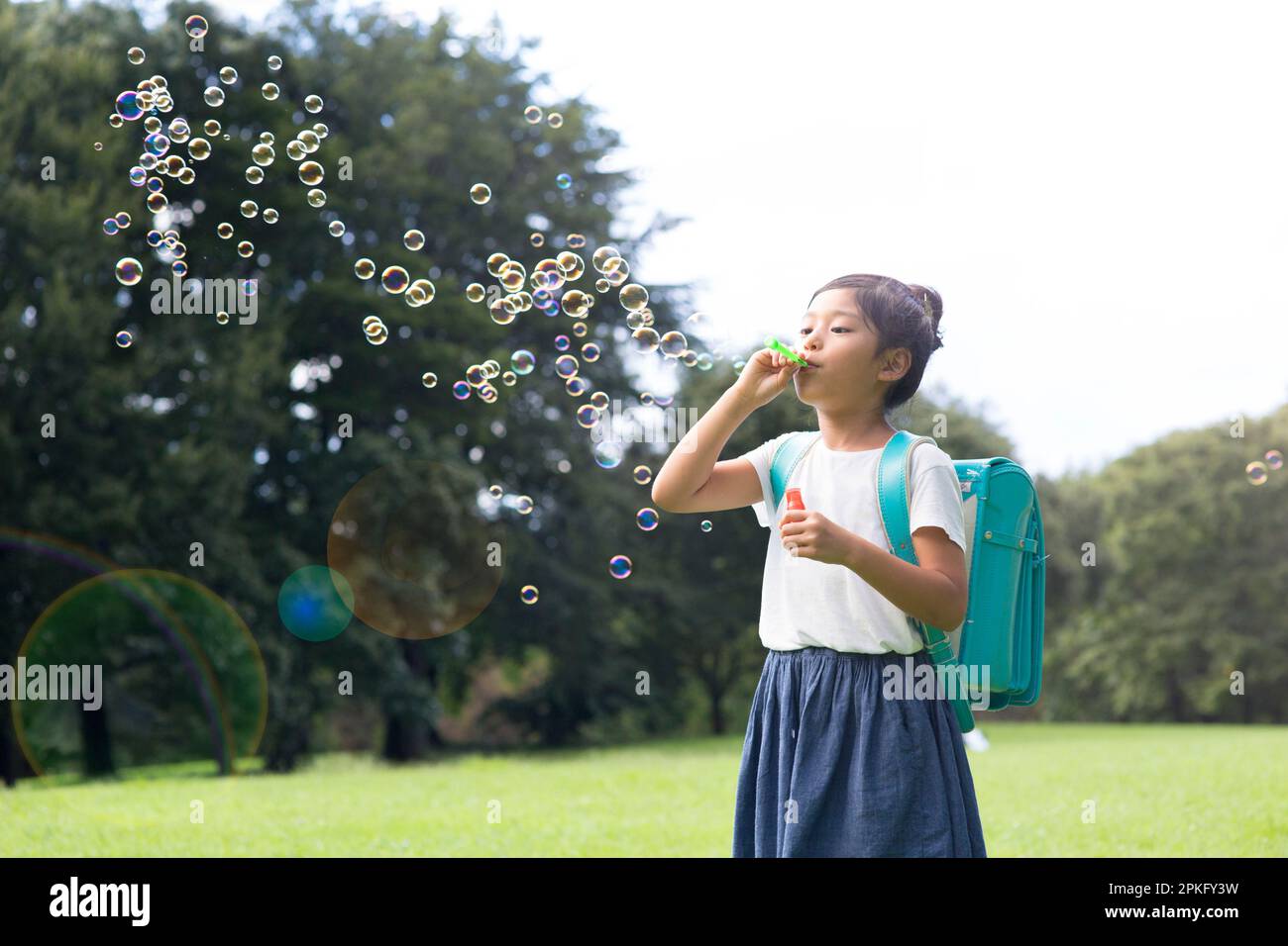 An elementary school girl playing with soap bubbles Stock Photo Alamy