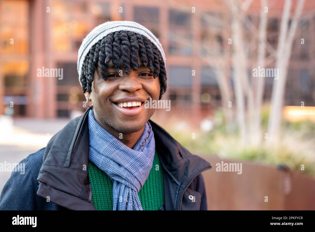 Portrait of a young African American man looking into camera and ...