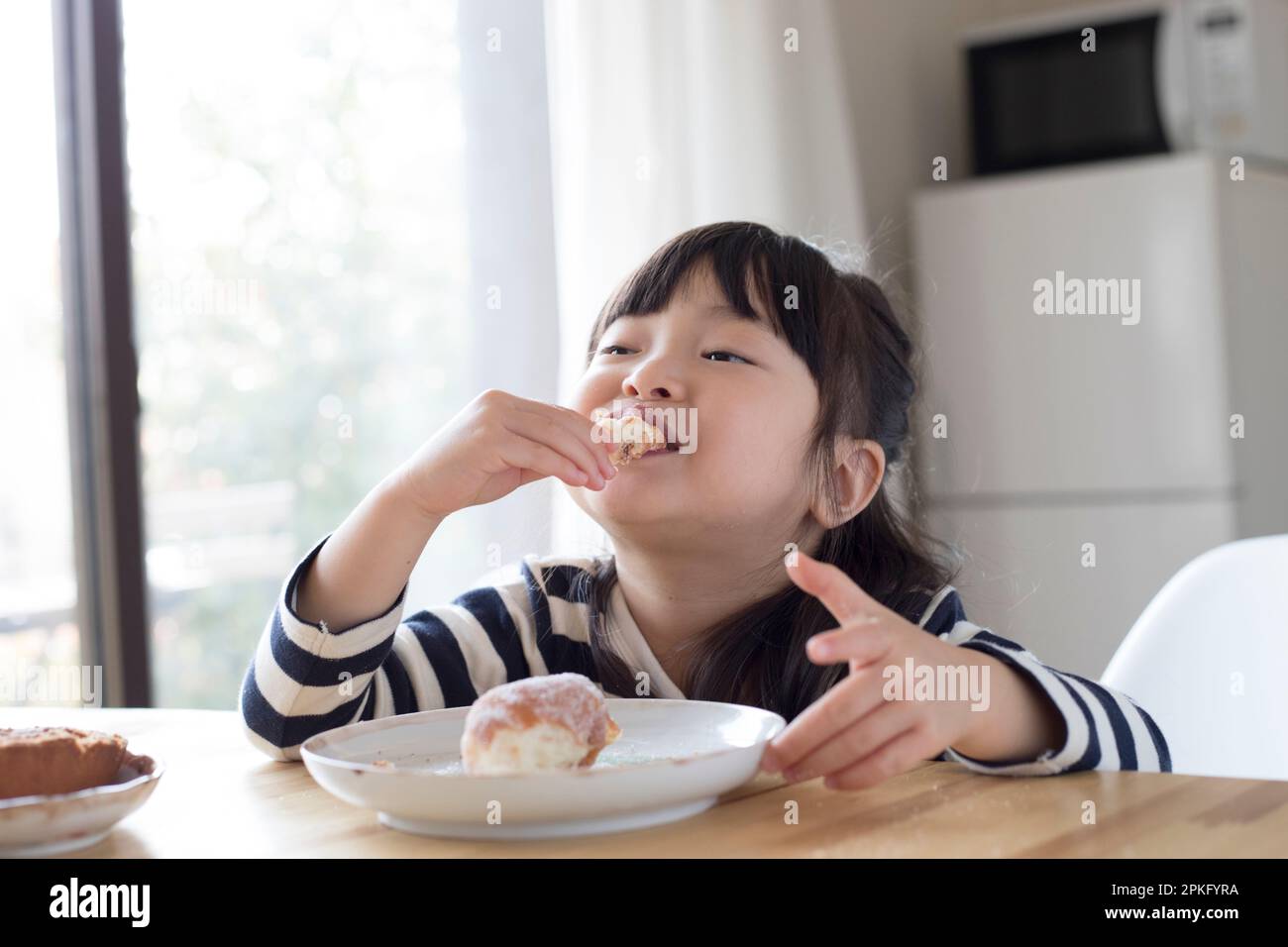 Girl eating a snack doughnut Stock Photo
