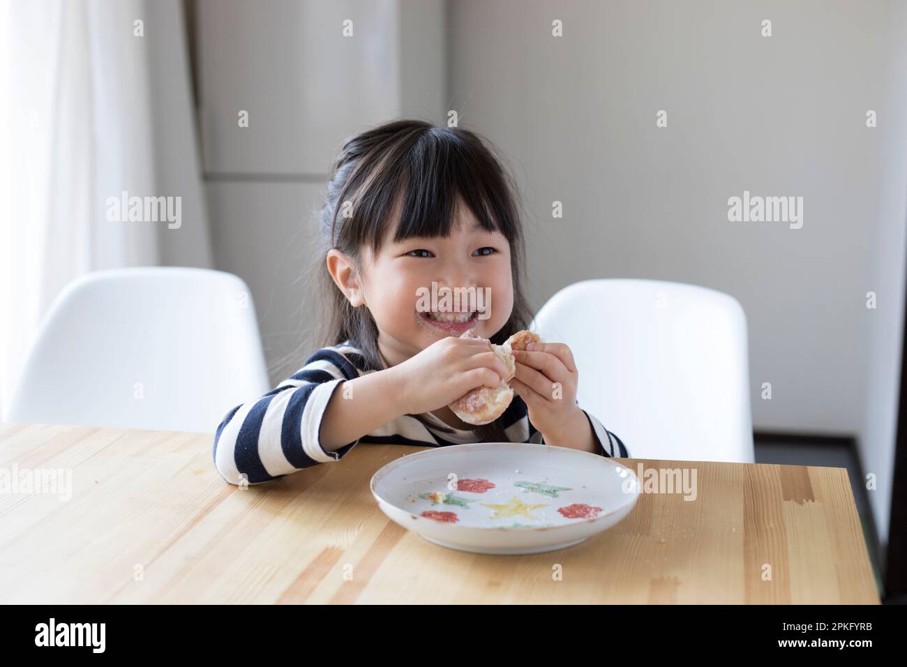 Girl eating a snack doughnut Stock Photo