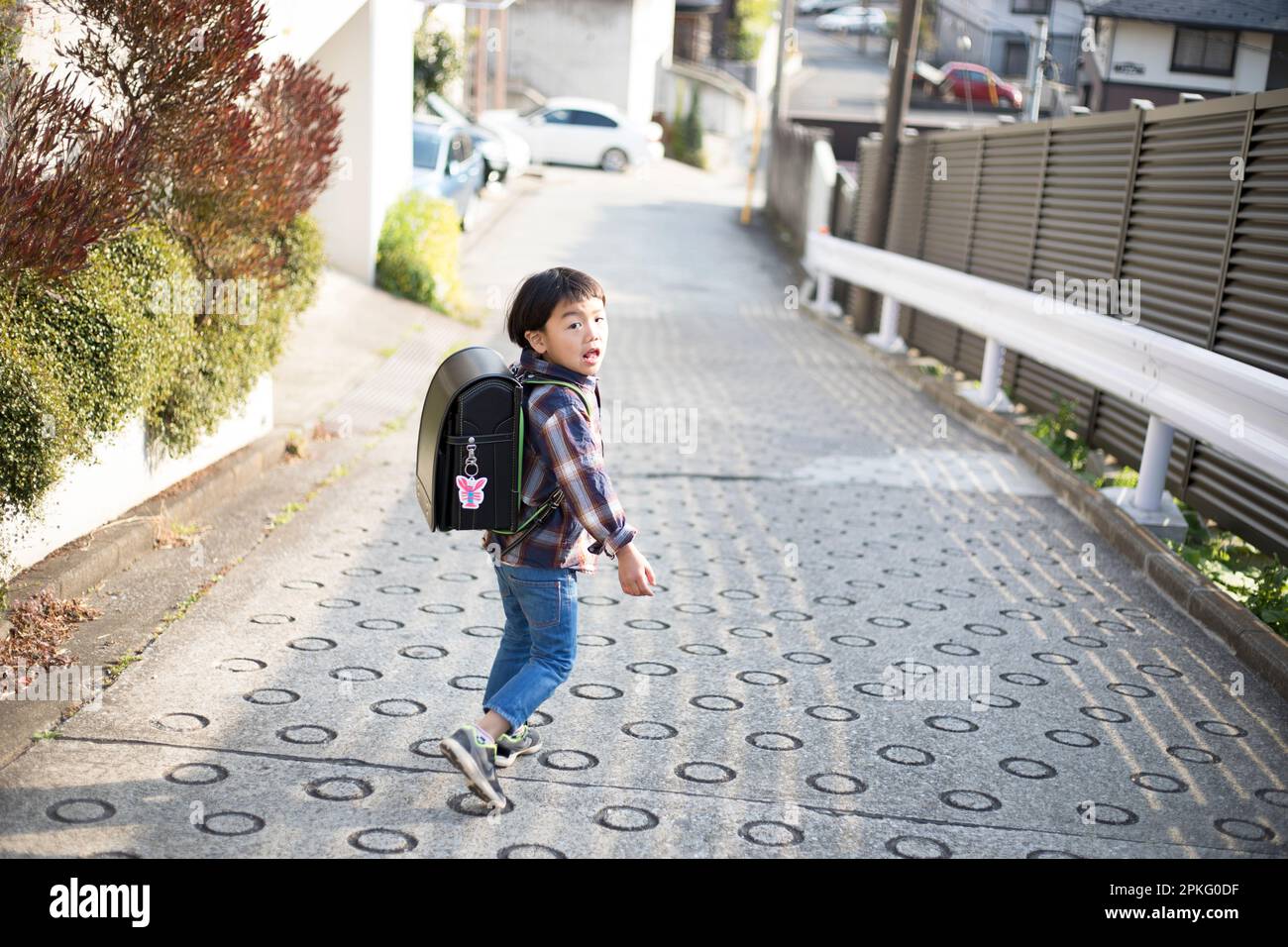A boy walking with his school bag on his back Stock Photo - Alamy