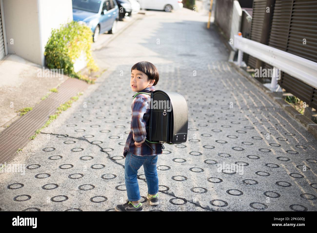 A boy walking with his school bag on his back Stock Photo - Alamy