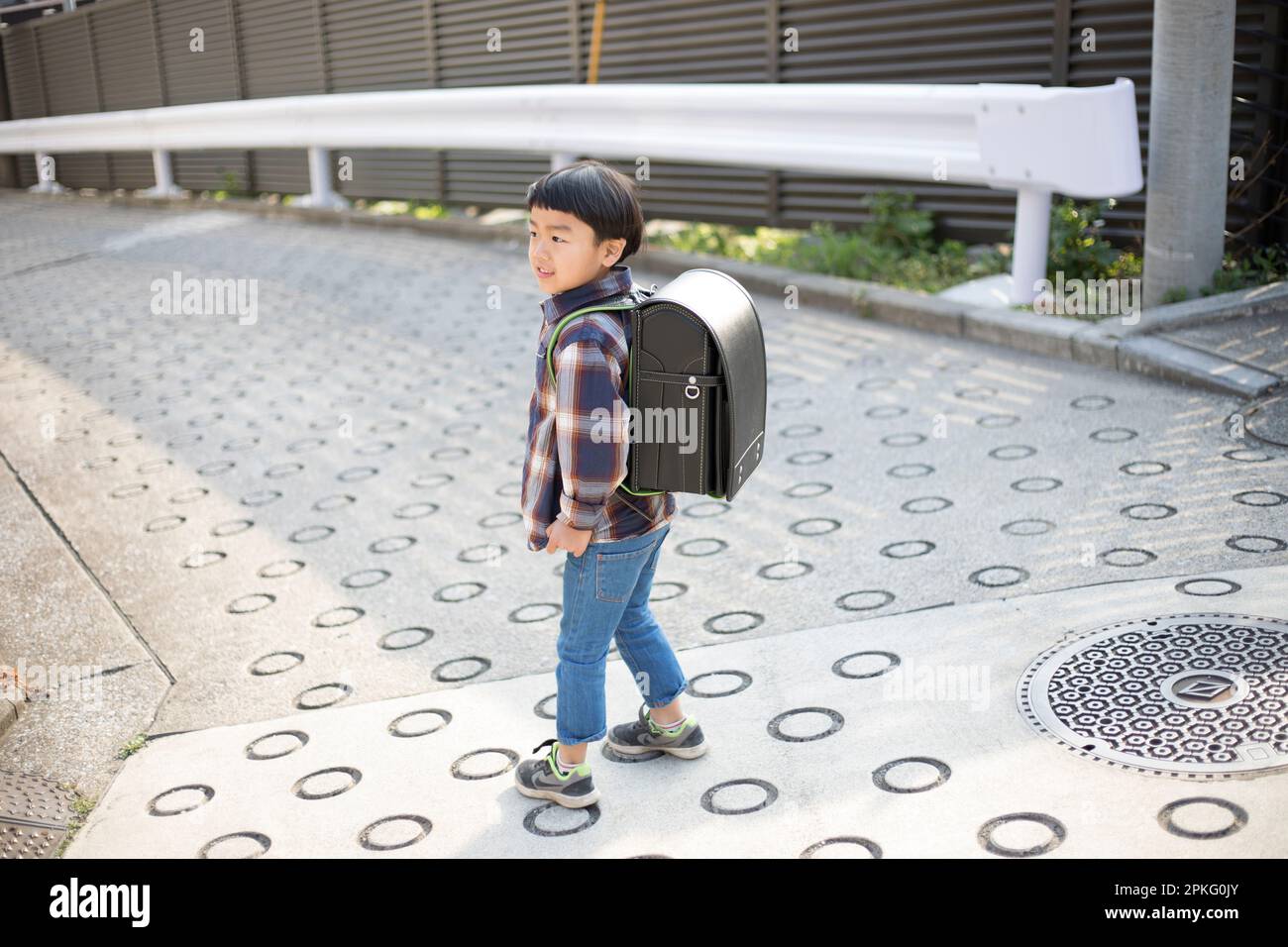Boy walking with school bag on his back Stock Photo - Alamy