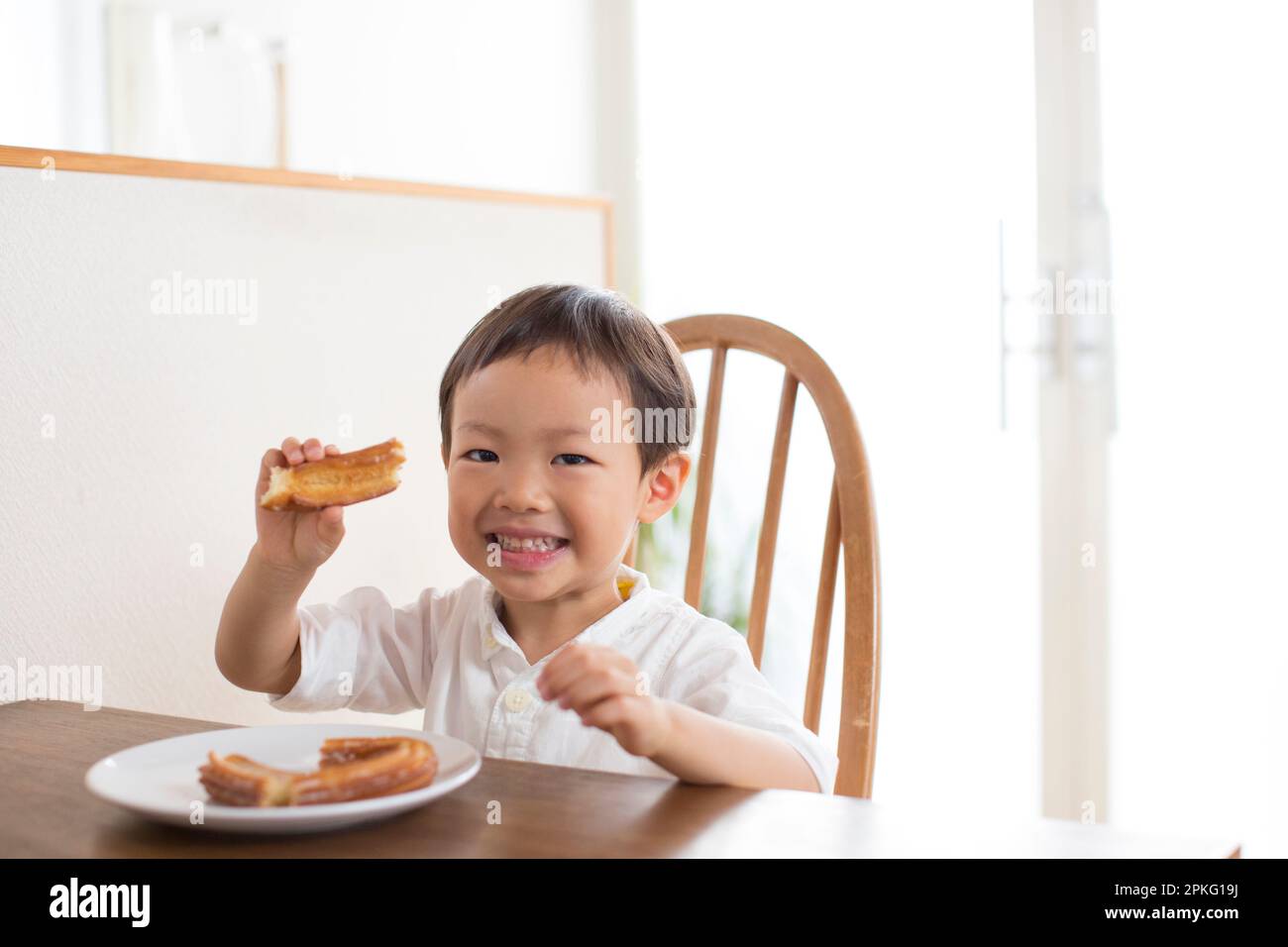 Boy eating snack at table Stock Photo - Alamy