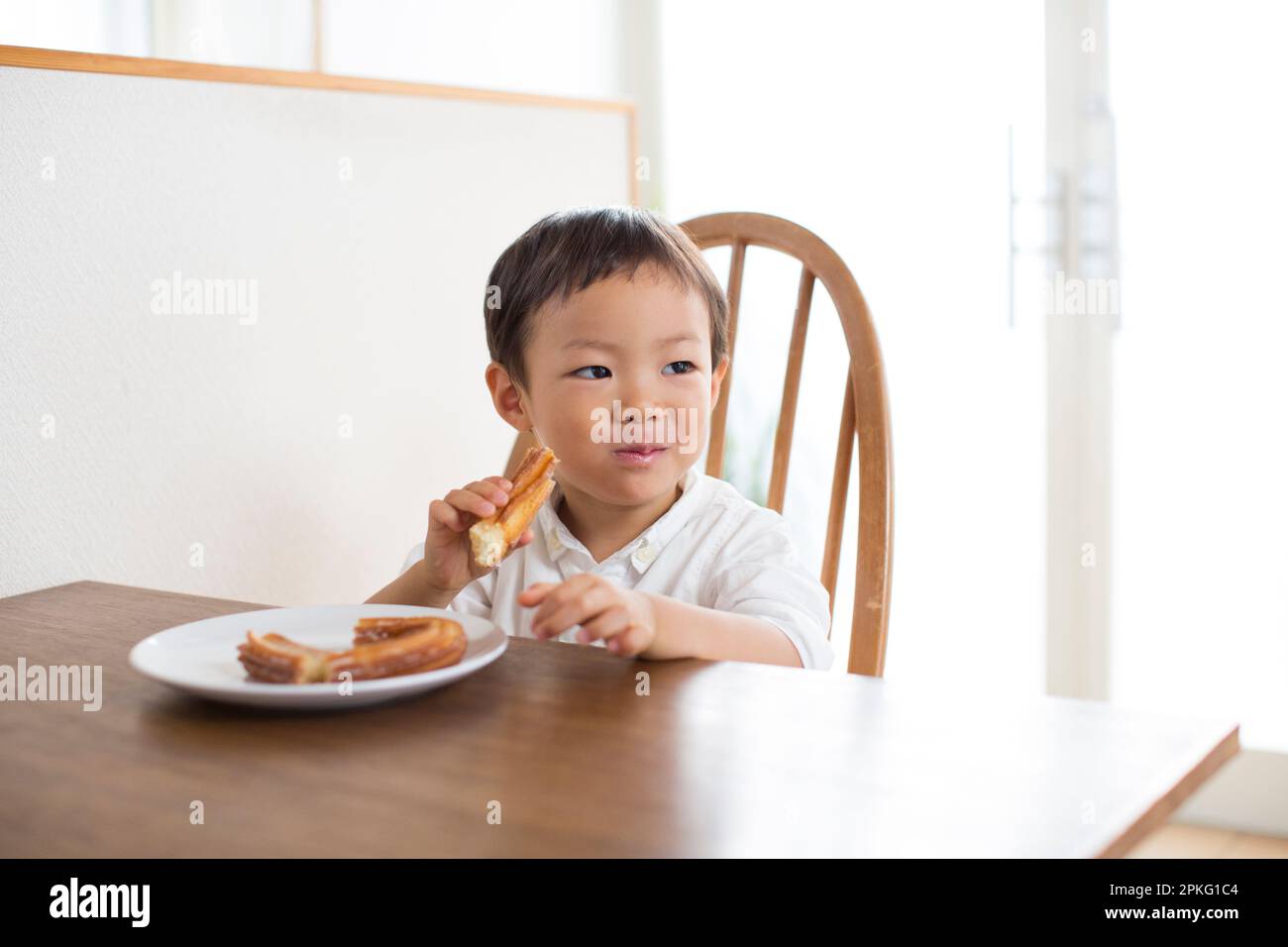 Boy eating snack at the table Stock Photo - Alamy