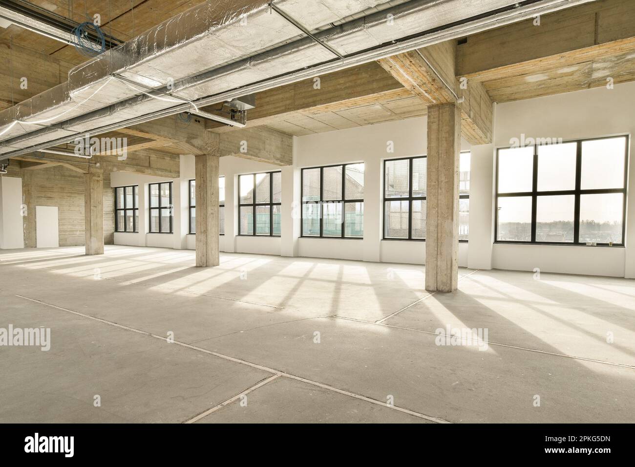 an empty office building with lots windows and light coming in from the sun shining through the window panoray Stock Photo